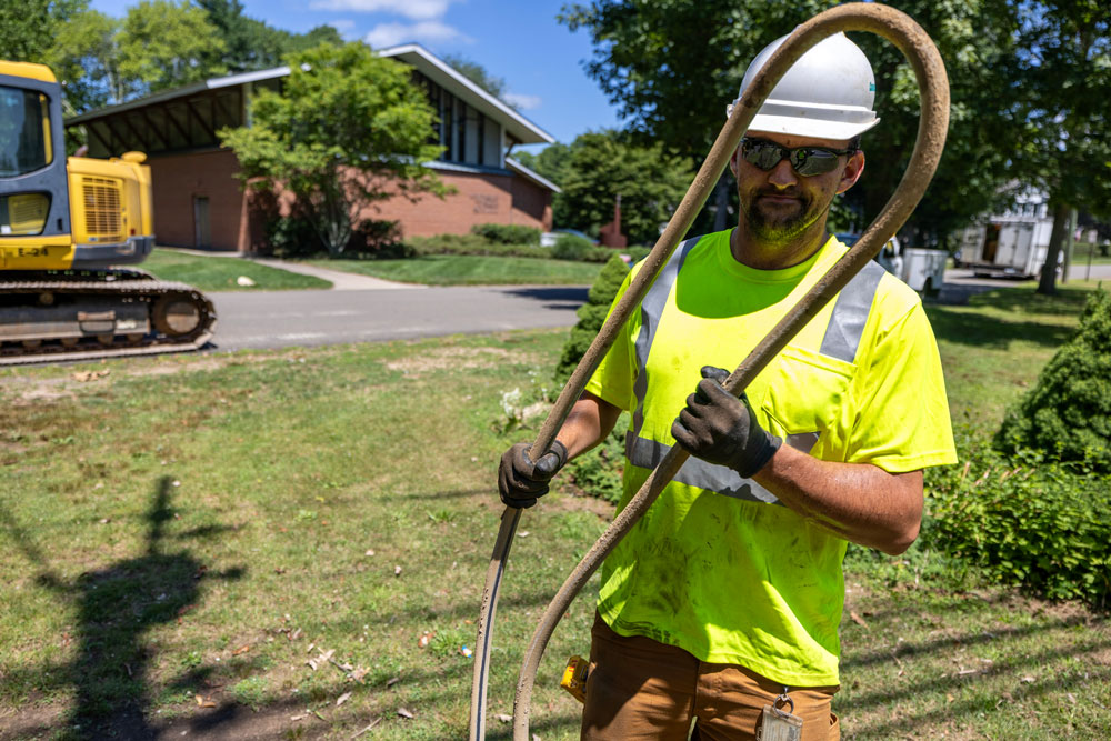 A Connecticut Water employee holds an old lead service line that was replaced.